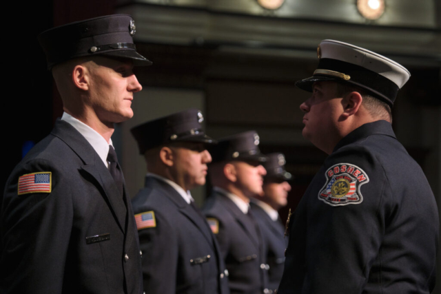 Goshen Fire Cheif Anthony Powell inspects recruit training graduates, from left, Charles Hoderbaum, Brian Guerra, Jeffery Gill and Ryan Rentfrow at Goshen Theater on Wednesday, April 2, 2025. (Photo credit: James Korn | Eyedart)