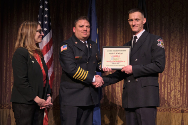 Goshen Fire Cheif Anthony Powell presents GFD Recruit Academy graduate Charles Holderbaum his certificate along with Mayor Gina Leichty on Wednesday, April 2, 2025 at the Goshen Theater.