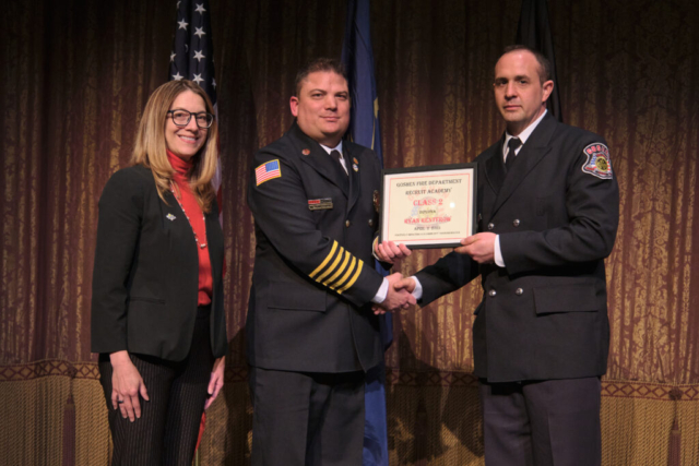 Goshen Fire Cheif Anthony Powell presents GFD Recruit Academy graduate Ryan Rentfrow his certificate along with Mayor Gina Leichty on Wednesday, April 2, 2025 at the Goshen Theater.